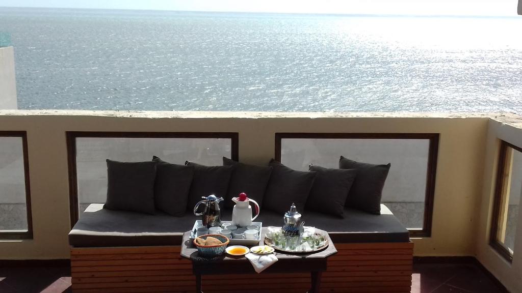 a couch on a balcony with a view of the ocean at Inyan Dakhla Hotel in Dakhla