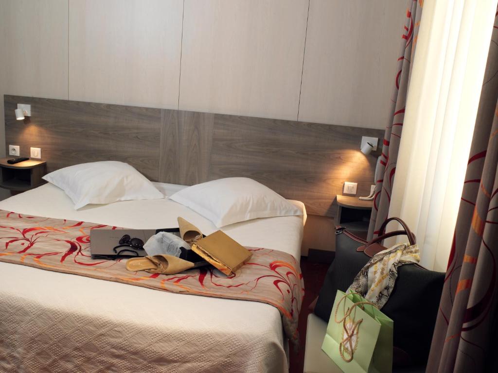 Postel nebo postele na pokoji v ubytování Brit Hotel Confort Le Revest Sainte-Maxime