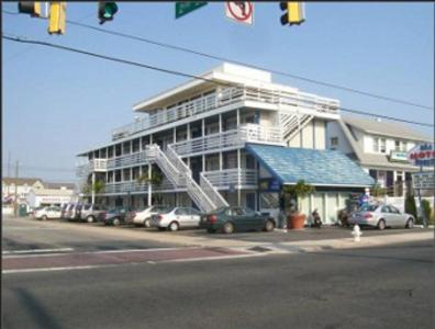 un gran edificio con coches estacionados frente a él en Sea Breeze Ocean City, en Ocean City