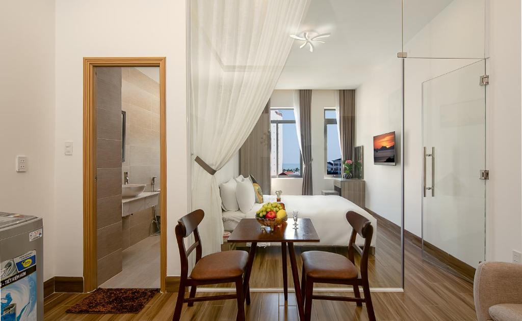 a room with a dining table and a bedroom at Van apartment in Da Nang