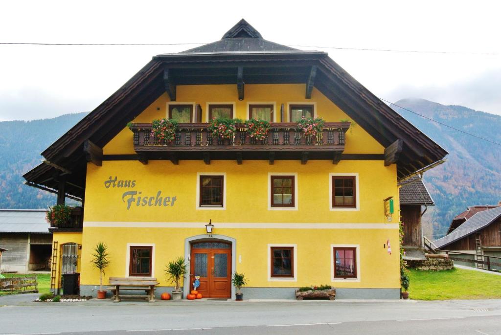 a yellow building with a balcony on top of it at Haus Fischer Nassfeldblick in Kirchbach