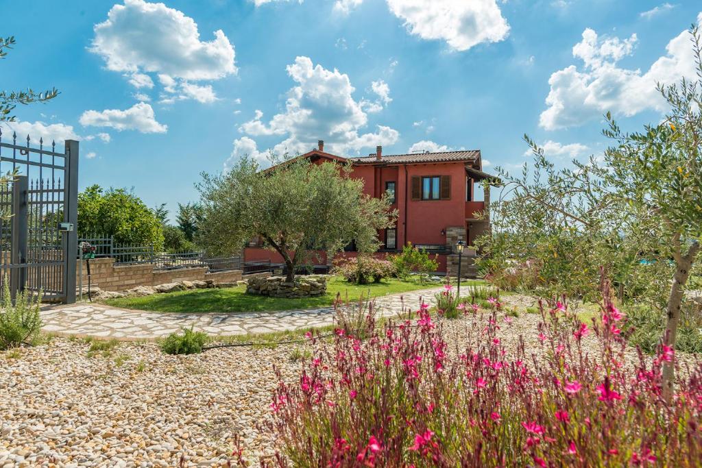 a house with a garden with pink flowers at Casale La Desdemona in Sutri