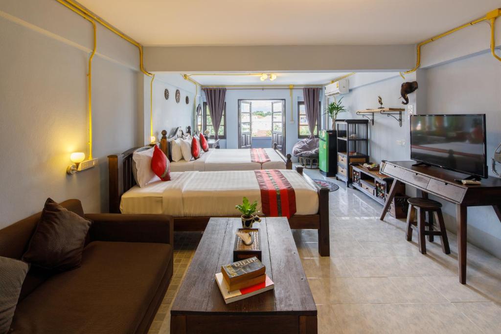 ein Hotelzimmer mit einem Bett und einem TV in der Unterkunft Double Lucky House in Chiang Mai