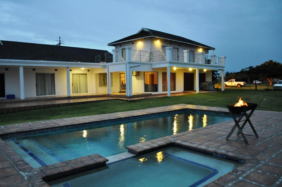 a house with a swimming pool in front of a house at SeaXplore Lodge & Dive Center in Sodwana Bay
