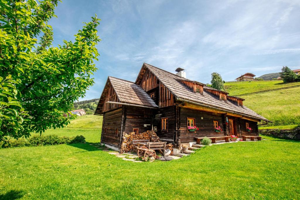 una cabaña de madera en un campo verde con un árbol en Napoleonvilla Holiday Home, en Rennweg