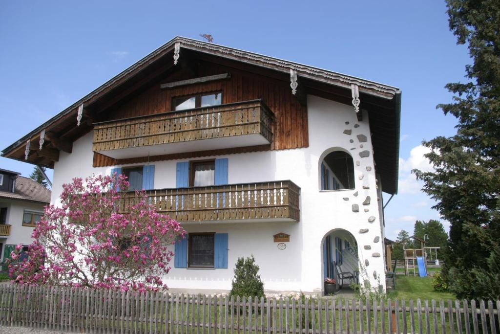 uma casa com uma varanda e uma cerca em Haus Magnolia em Schwangau