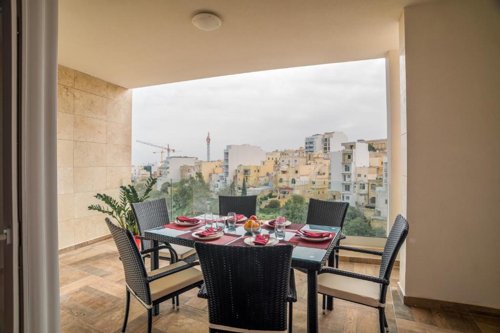 a dining room with a table and chairs and a large window at Luxury Valley View St Julians in St Julian's