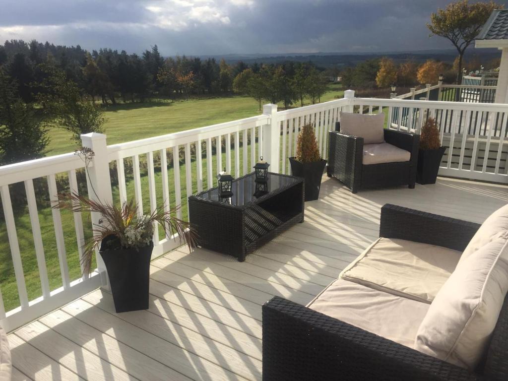 a deck with chairs and a table on a fence at Valley View in Swarland