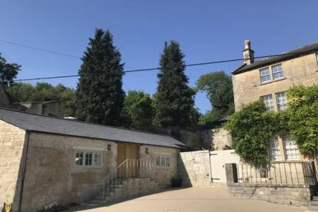an old stone building with trees in the background at SKITTLES - charming one bedroom apartment - parking - easy access to Bath in Box