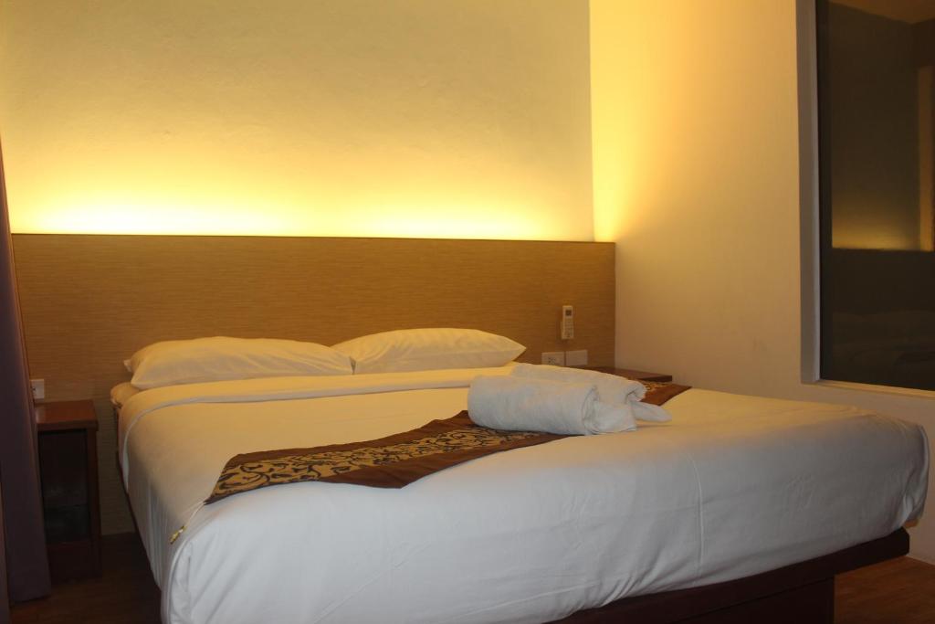 1 dormitorio con 1 cama grande con sábanas y almohadas blancas en Freedom Kata, en Kata Beach