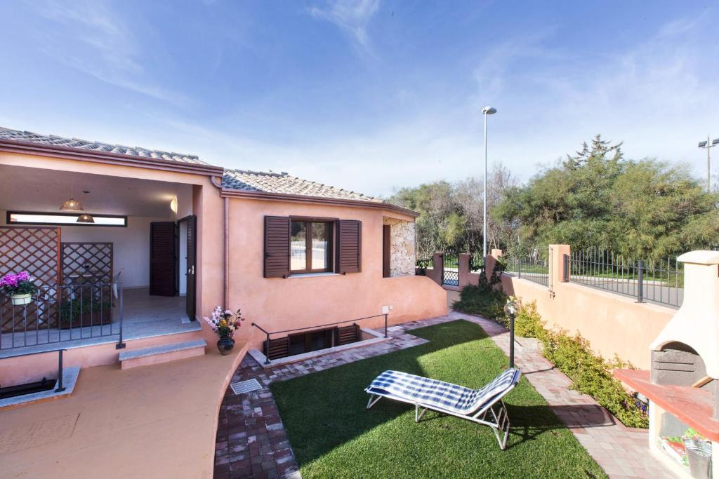 a house with a blue bench in a yard at Villetta Laura 350 mt Baia di Porto Frailis in Àrbatax