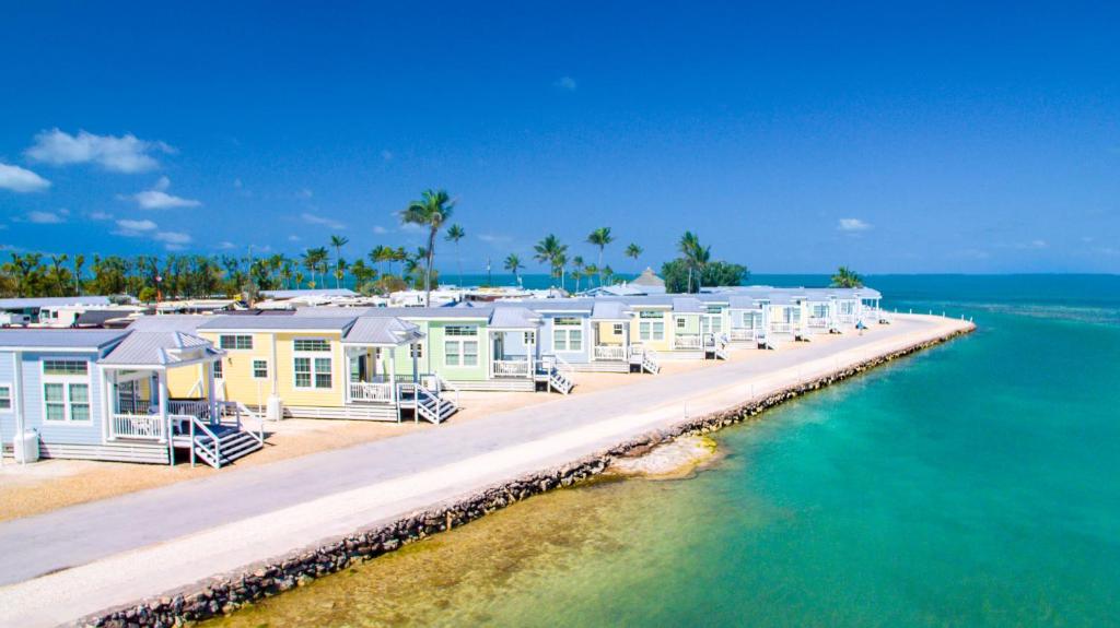 a row of houses on a dock in the water at Fiesta Key RV Resort Waterfront Cottage 33 in Layton