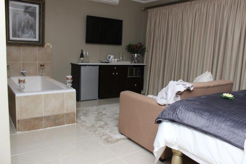 Bloemfontein的住宿－Reliwave Pty Ltd，一间卧室配有一张床、一个浴缸和一台电视。