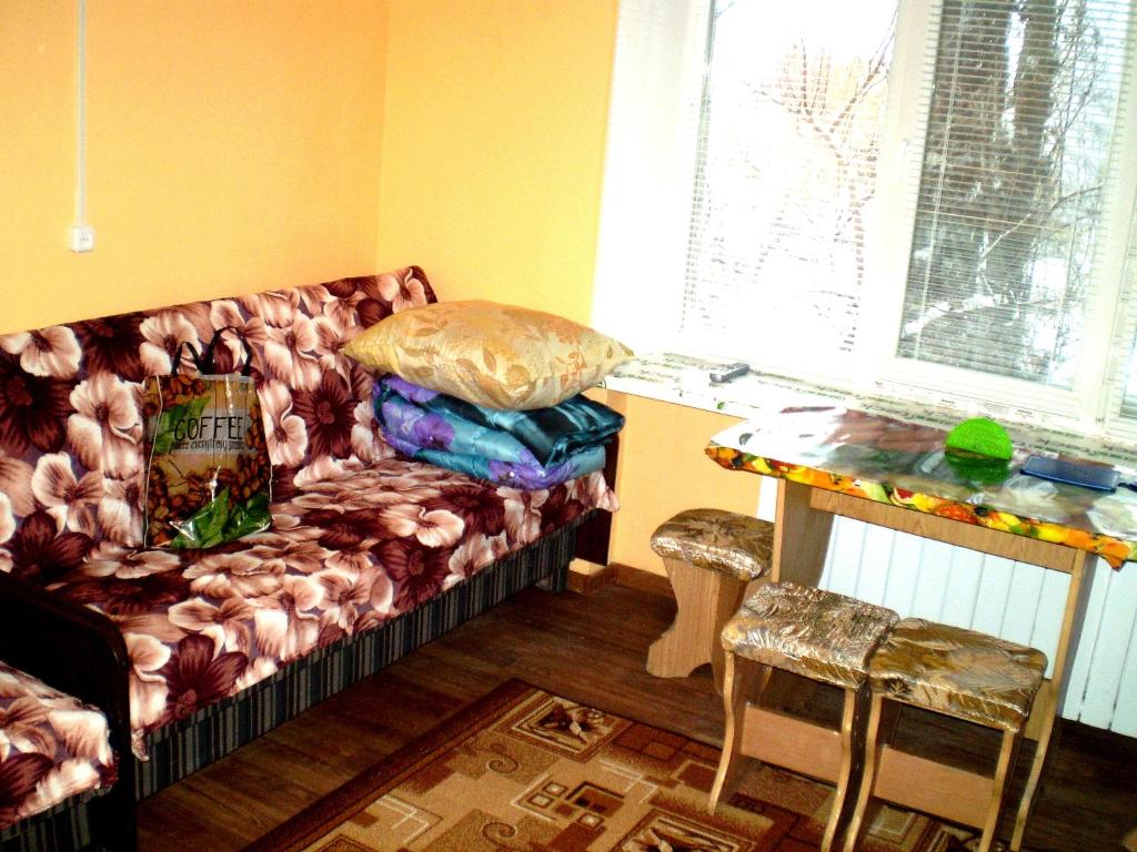 un sofá sentado en una habitación con una mesa en НЕБОЛЬШАЯ СТУДИЯ проспект Центральный 124А WI-FI 2 дивана 3 этаж 9 этажного дома, en Mykolaiv
