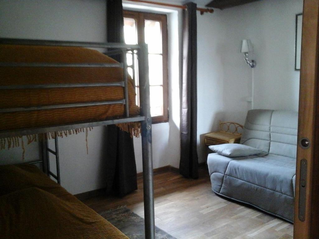 les Millefonds في فالديبلور: غرفة نوم مع سرير بطابقين وأريكة