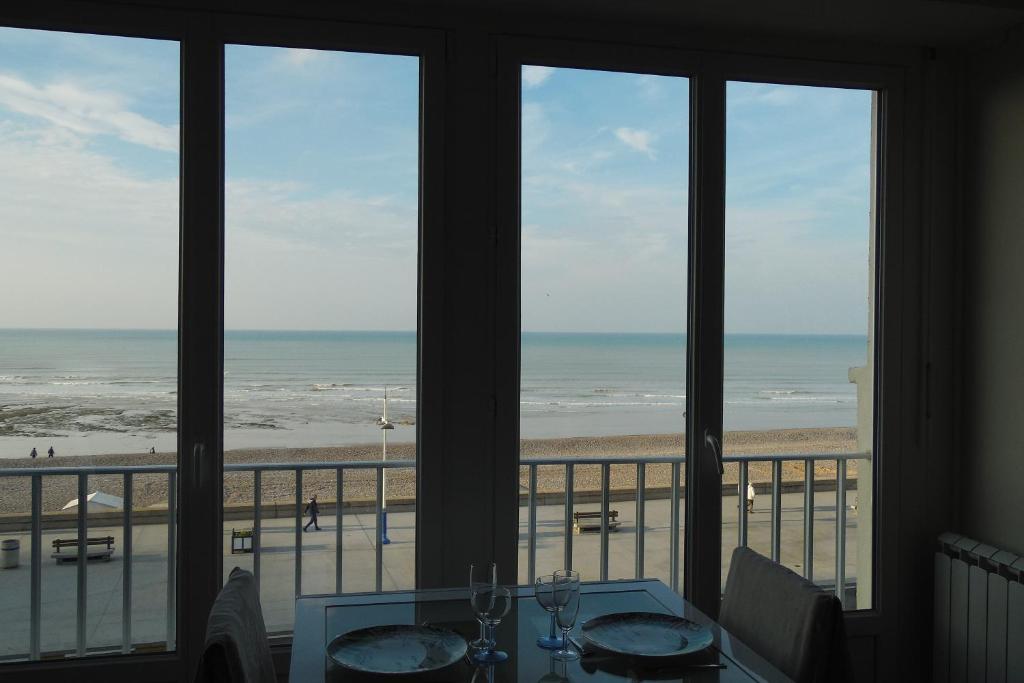 una sala da pranzo con vista sulla spiaggia di L' entre mer et falaise a Le Tréport