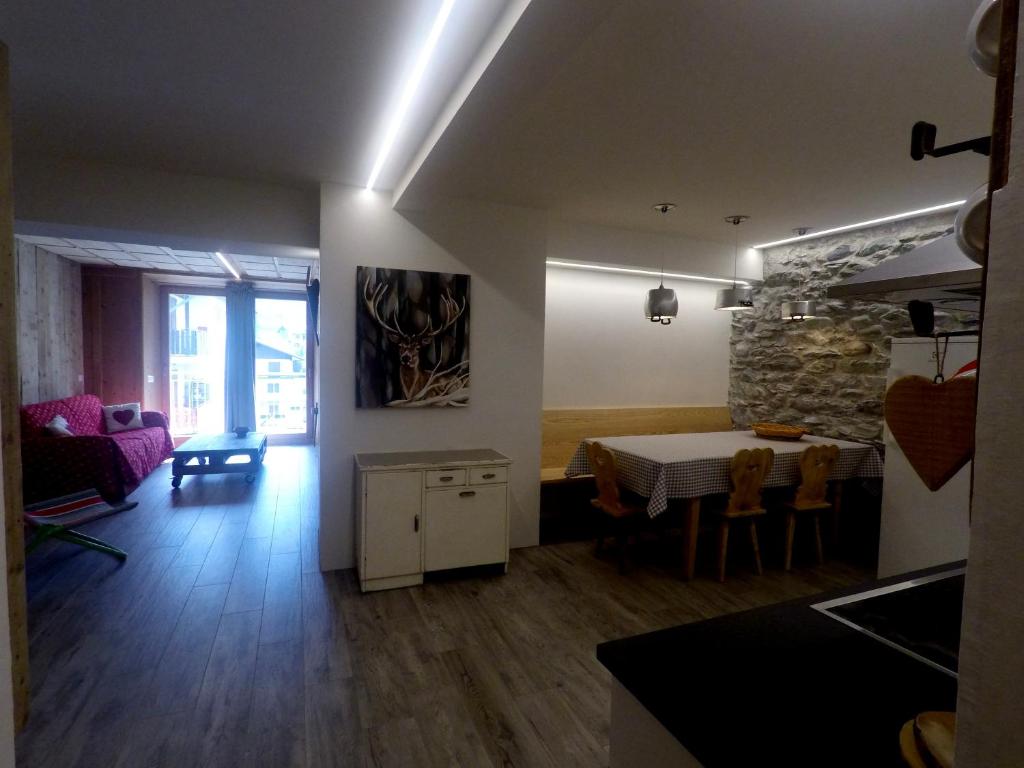 kuchnia i salon ze stołem i jadalnią w obiekcie Appartamento SALIC w mieście Bormio