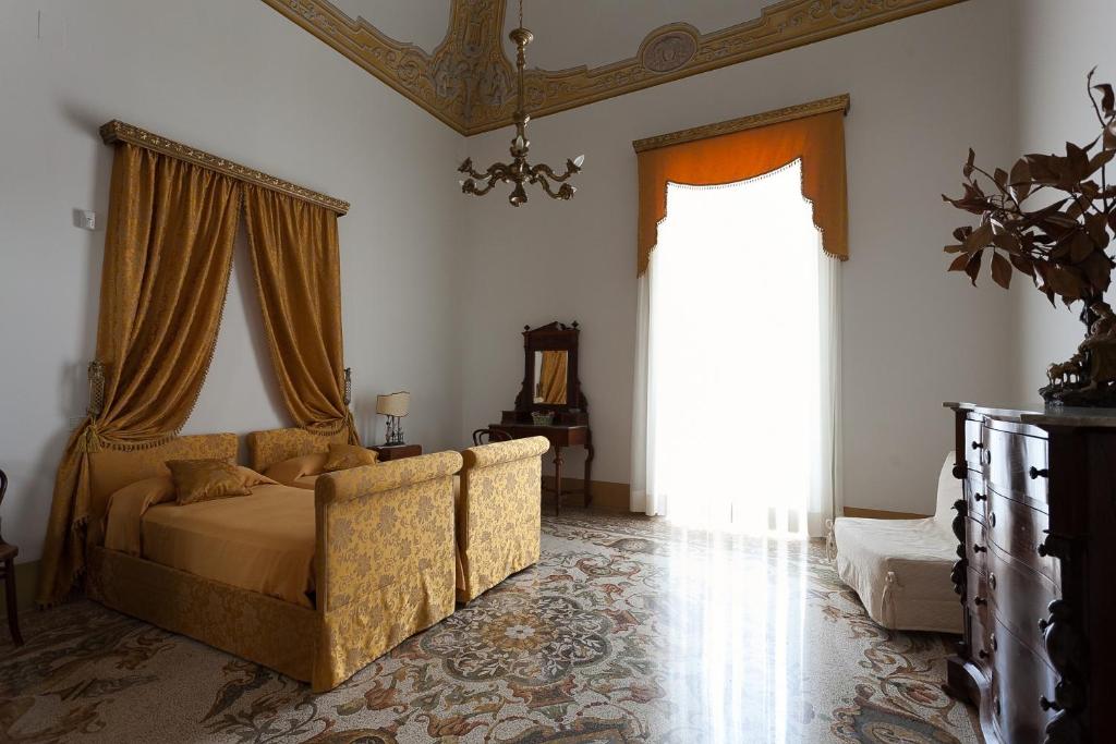 una camera con un letto e una grande finestra di Palazzo Pio Apartment a Lecce