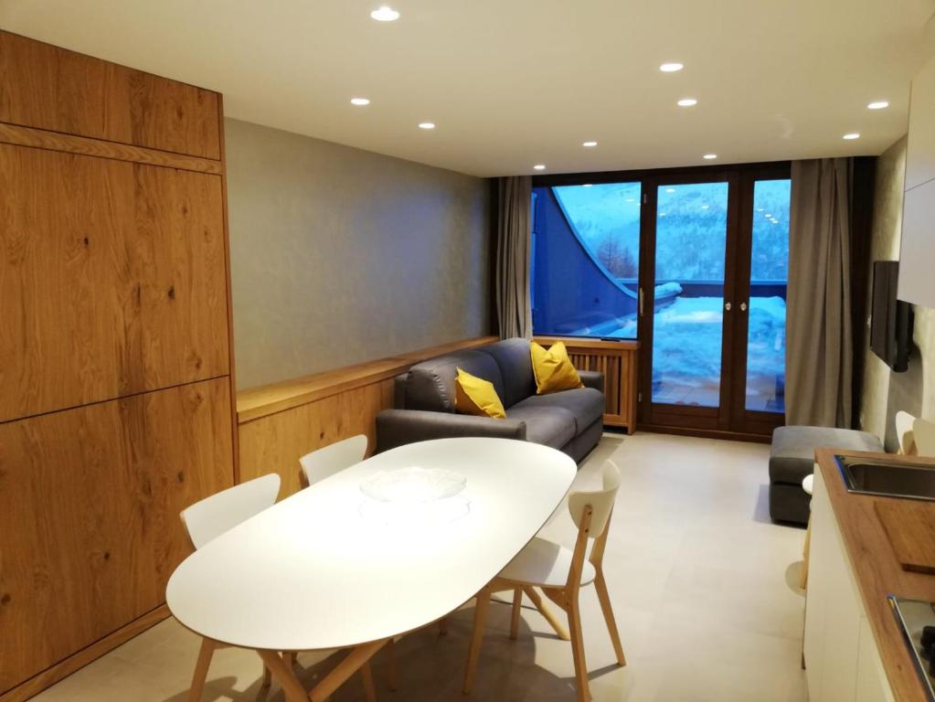 uma sala de estar com uma mesa branca e um sofá em La stella alpina Cervinia Vda Vacanze in Vetta CIR 0250 em Breuil-Cervinia