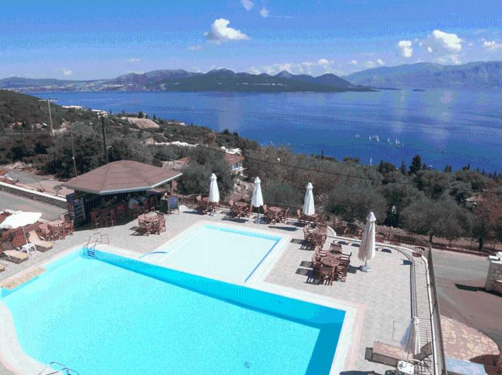 a large swimming pool with a view of the water at Anastasia Village in Nikiana