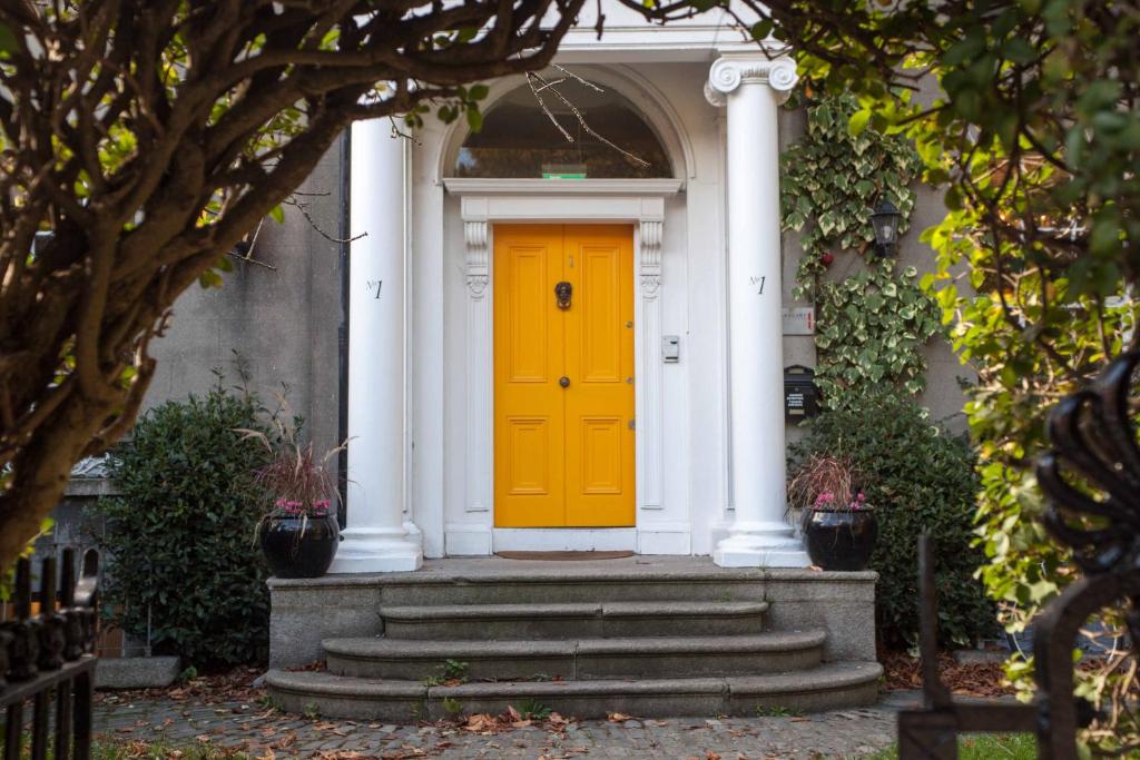 a yellow door on the front of a house at The Historical Harcourt Suites in Dublin
