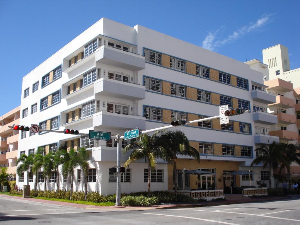 a white building with palm trees in front of it at Westover Arms Hotel in Miami Beach