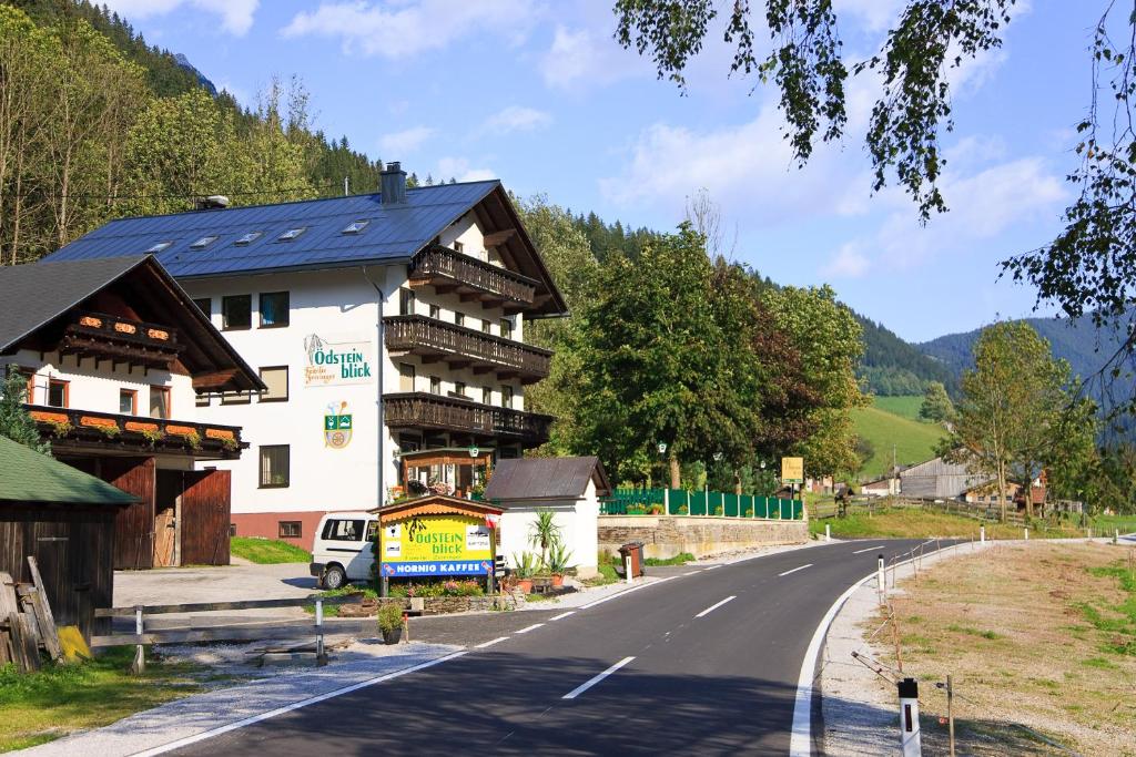 ein großes Gebäude am Straßenrand in der Unterkunft Gasthof - Pension Ödsteinblick in Johnsbach