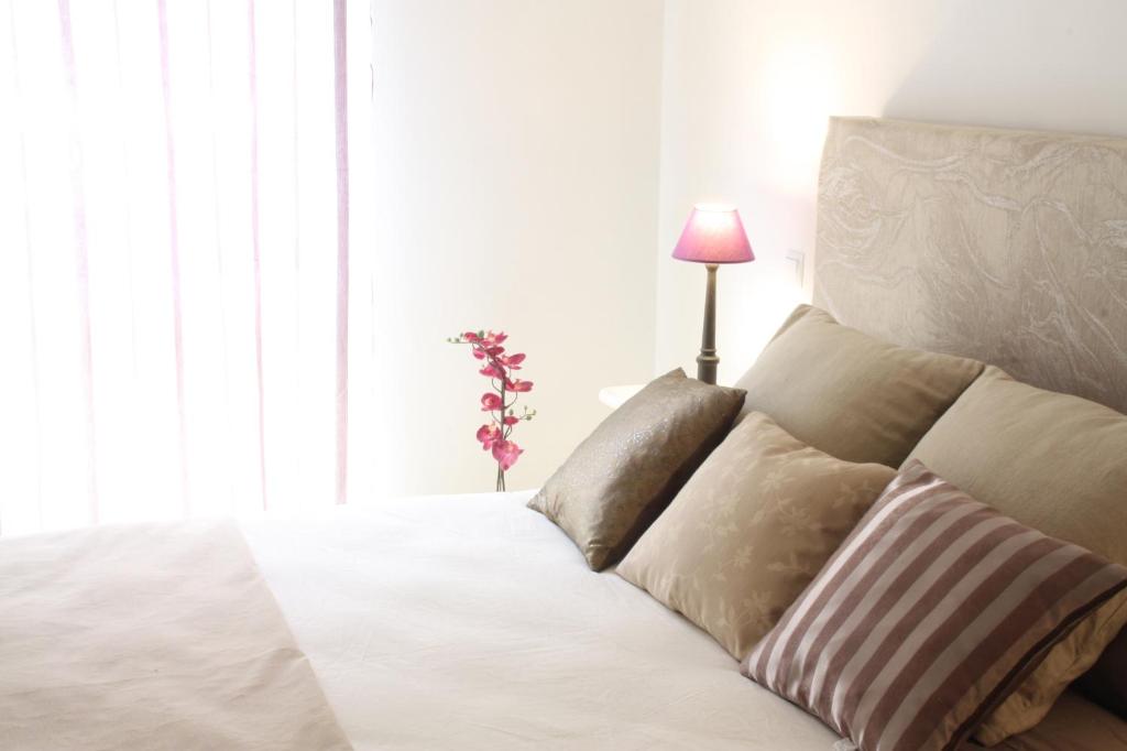 ラスパルマス・デ・グランカナリアにあるCanteras Blissのベッド(白いシーツ、枕、ランプ付)
