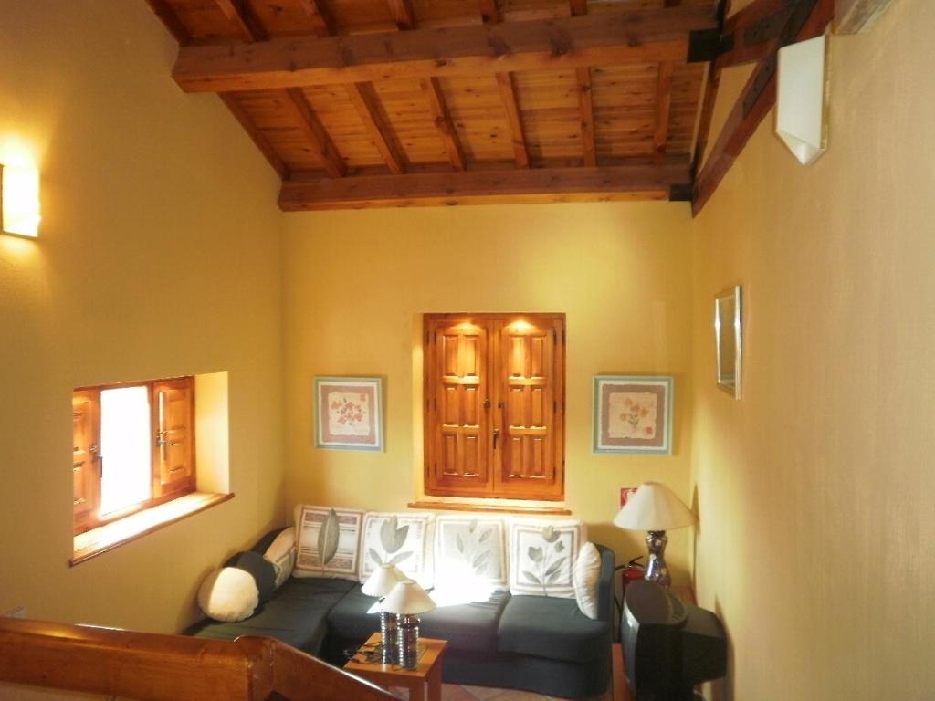 sala de estar con sofá y ventana en Posada de Serrada, en Serrada de la Fuente