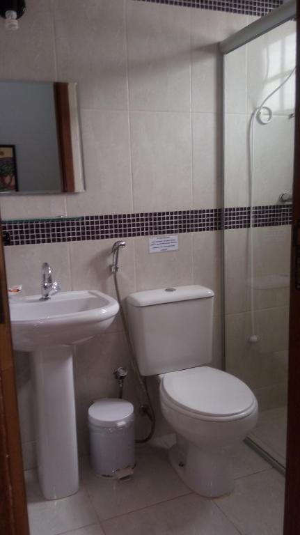 a bathroom with a toilet and a sink and a shower at Pousada Licuri in Serra do Cipo