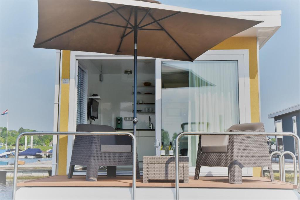 a patio with two chairs and an umbrella at Boatlodge, Anegada in Maastricht