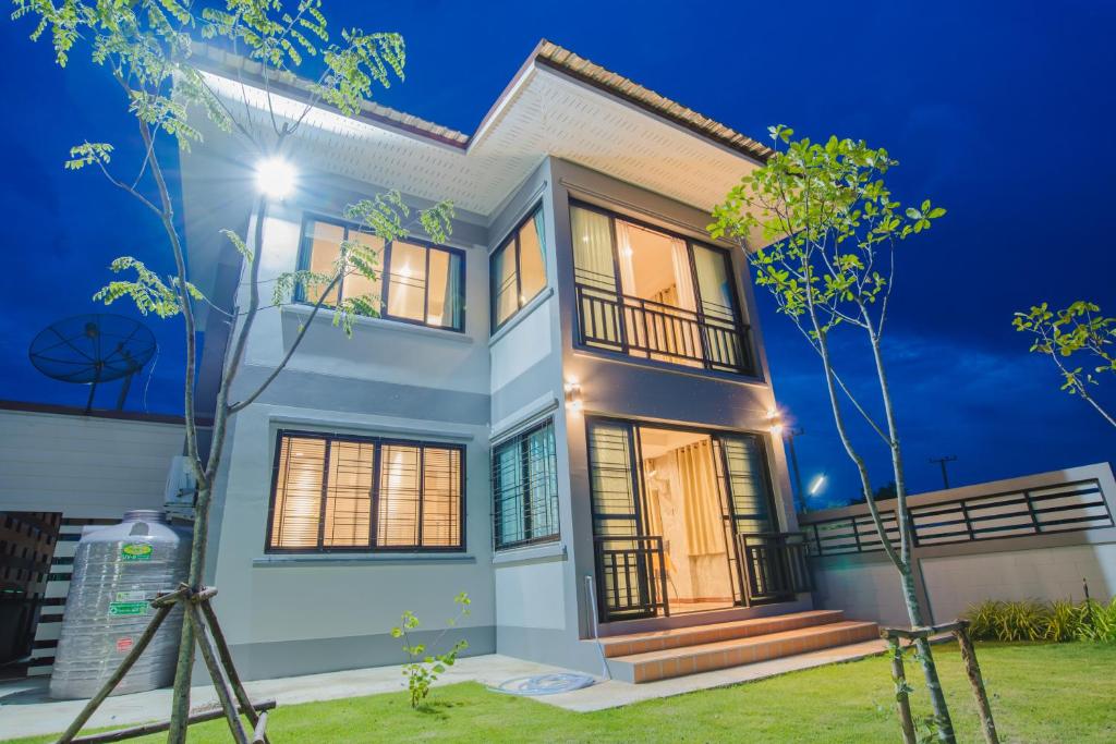 una casa por la noche con las luces encendidas en Riverview Loft house, en Uthai Thani