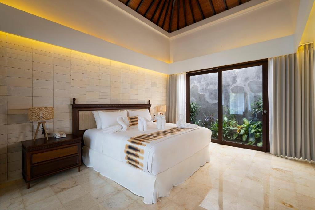 Säng eller sängar i ett rum på The Kemilau Hotel & Villa Canggu Bali