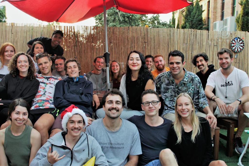 um grupo de pessoas posando para uma foto sob um guarda-chuva em Landing Pads Brunswick em Melbourne