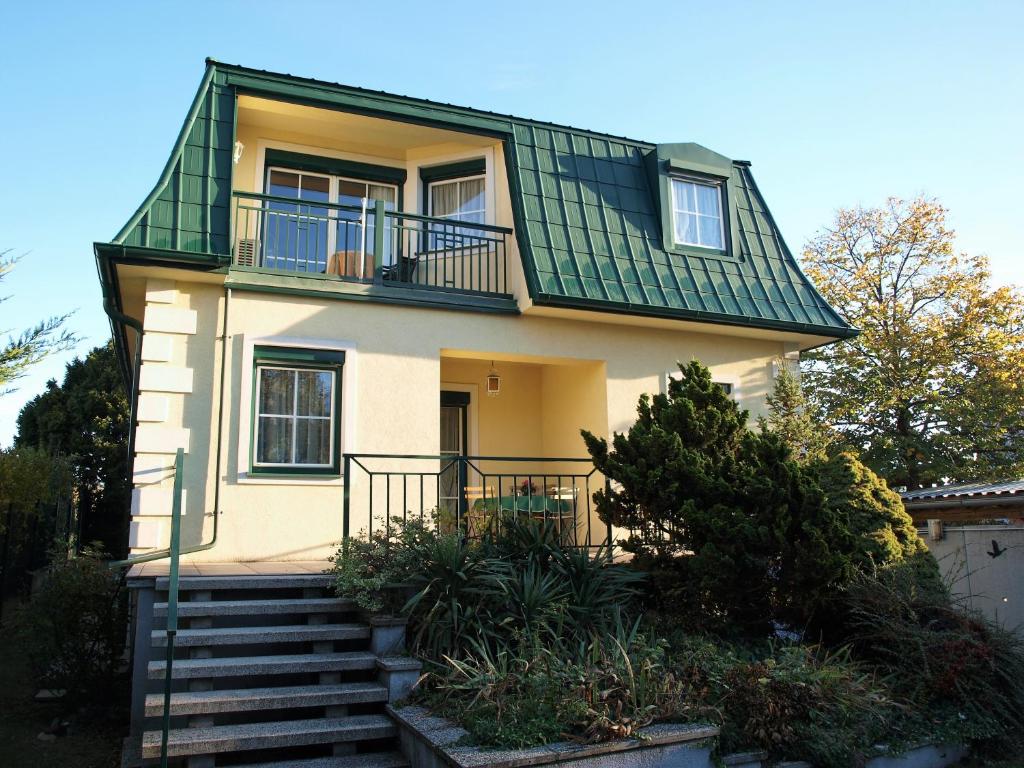 a small house with a green roof and stairs at Charmantes Apartment mit Terrasse zum Garten nahe Wien in Gumpoldskirchen