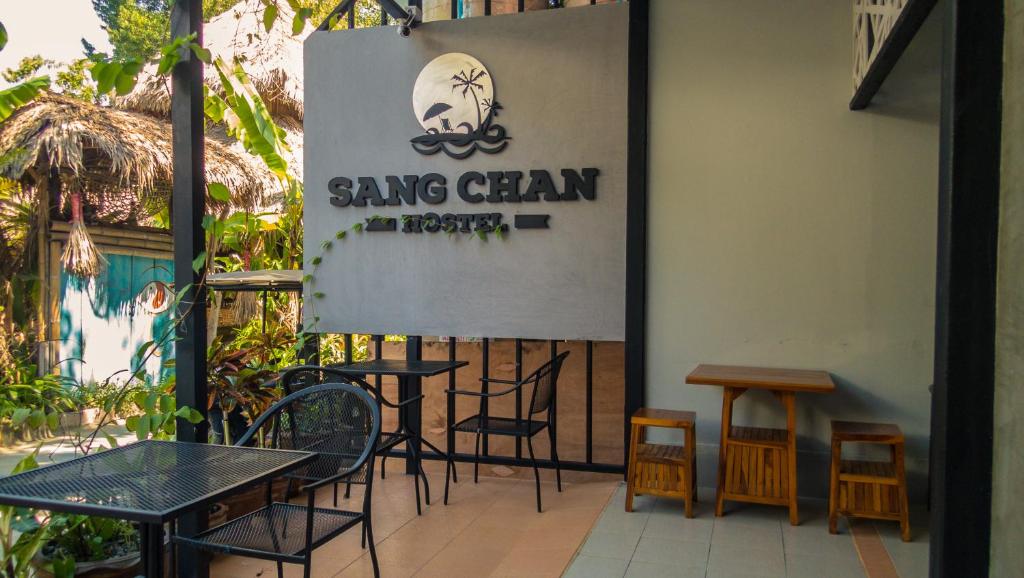a group of tables and chairs on a patio at Sangchan hostel in Ko Lipe