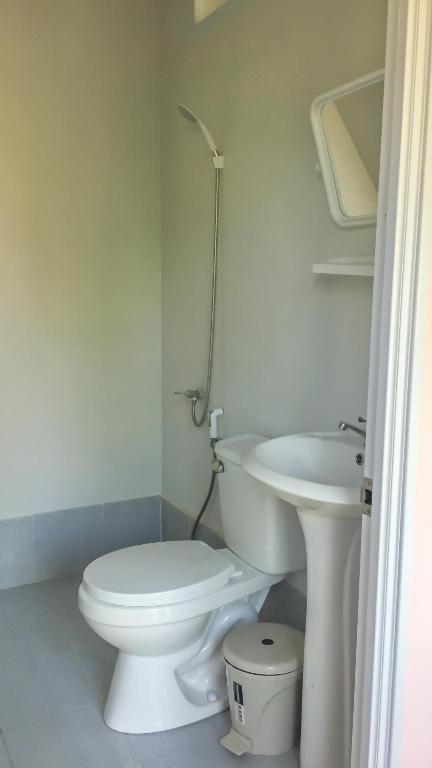 a white bathroom with a toilet and a sink at Sangchan hostel in Ko Lipe