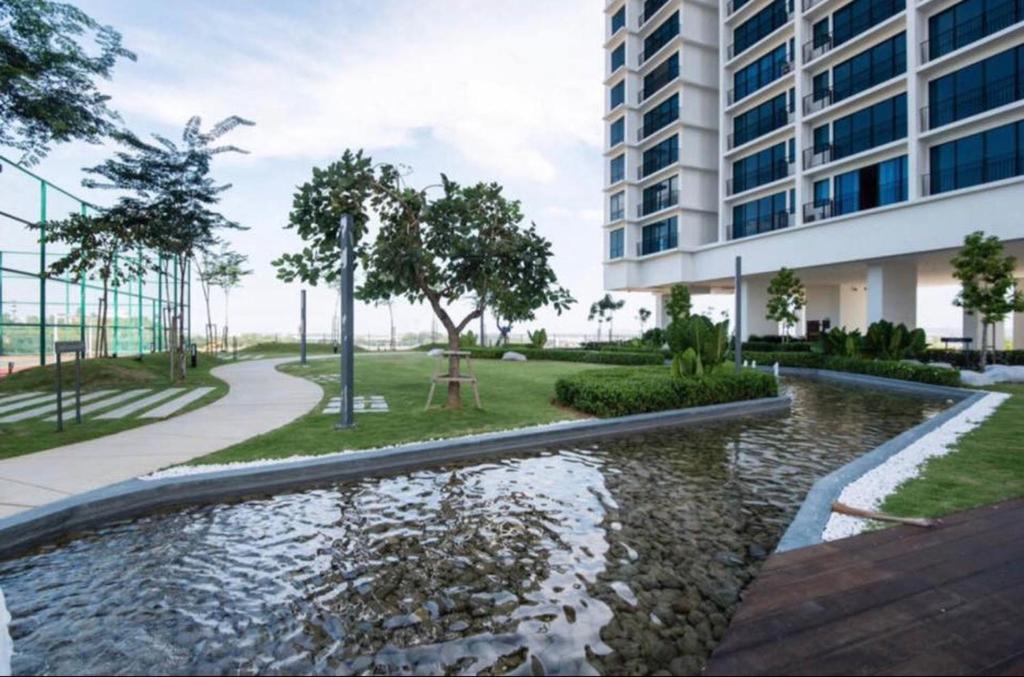 een hotel met een vijver voor een gebouw bij 2-Bedroom Apartment@Trefoil Setia Alam in Shah Alam