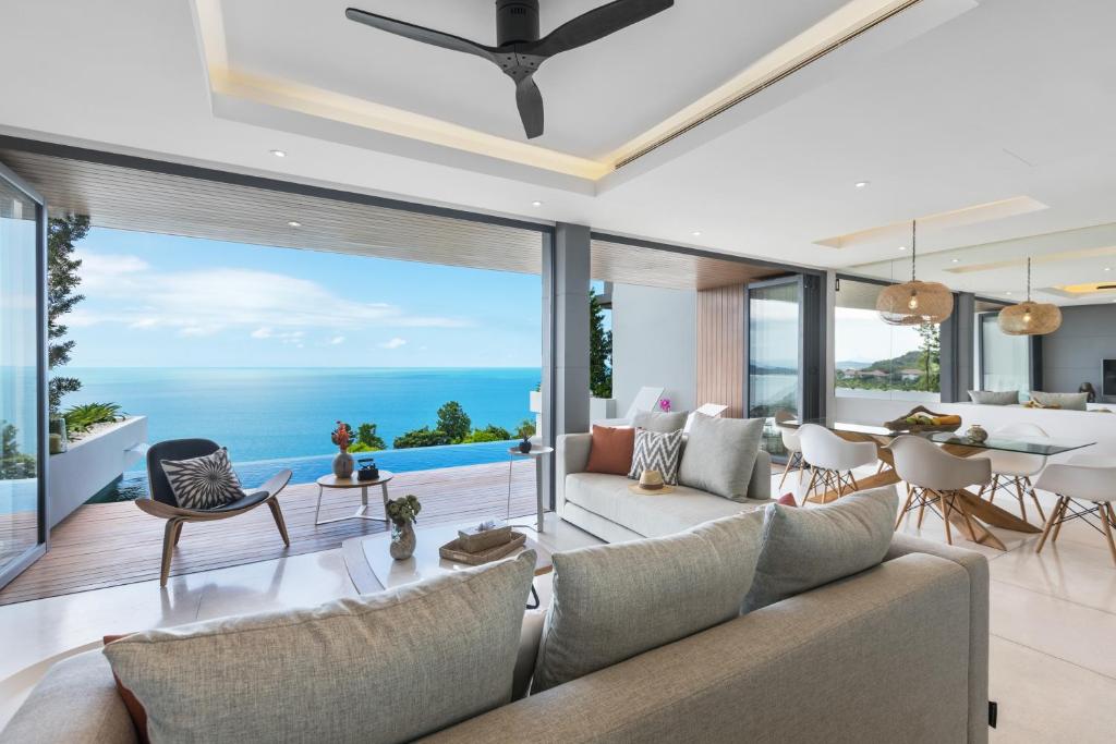 una sala de estar de planta abierta con vistas al océano en Sukkho Samui Estates, en Chaweng Noi Beach