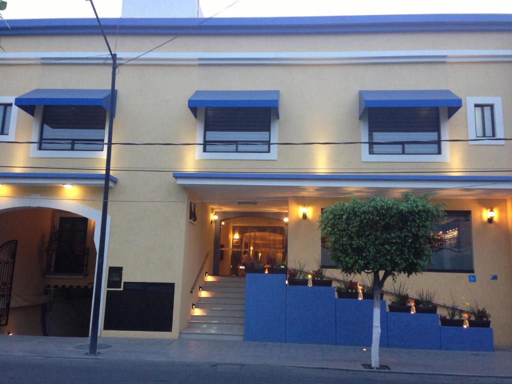 un edificio con toldos azules en la parte delantera en Hotel CR Tehuacan, en Tehuacán