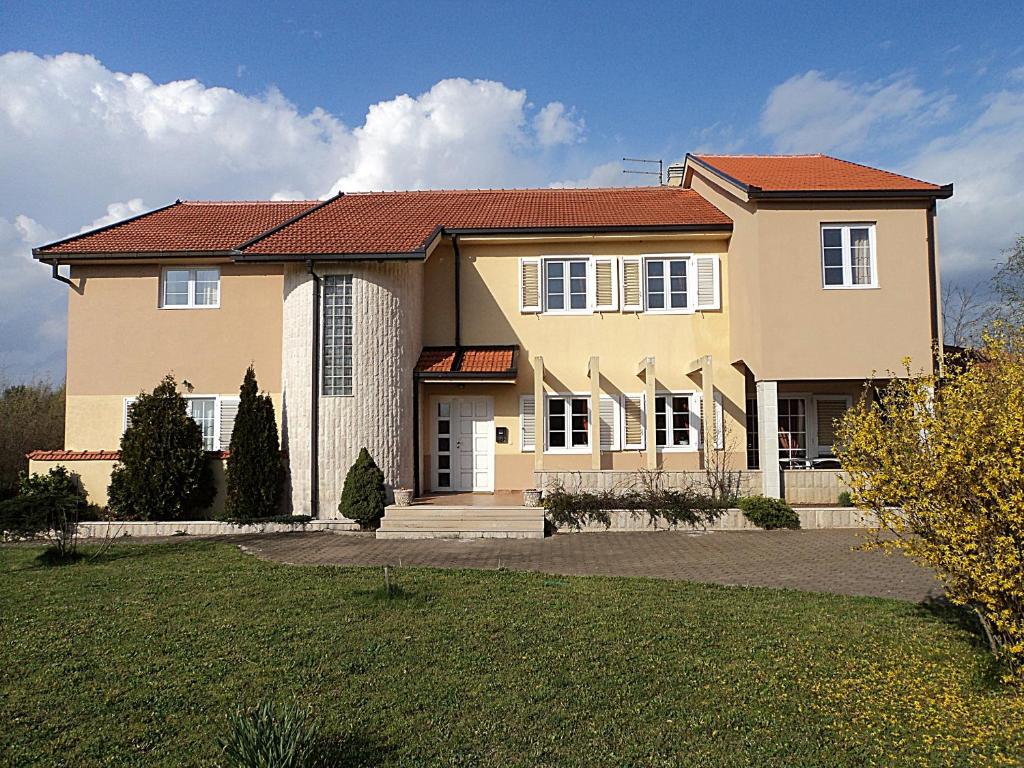 una gran casa amarilla con techo rojo en Villa Zovko, en Međugorje