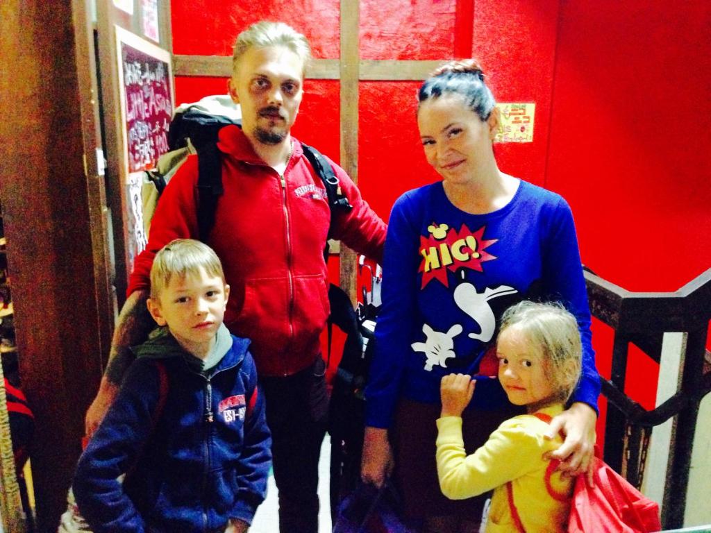 a man and a woman and two children posing for a picture at Little Asia Guest House in Naha