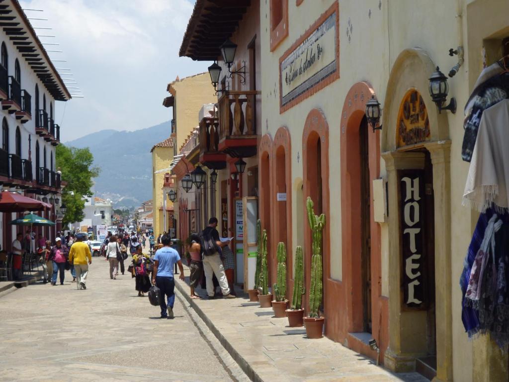 un grupo de personas caminando por una calle con edificios en Hotel San Martin, en San Cristóbal de Las Casas