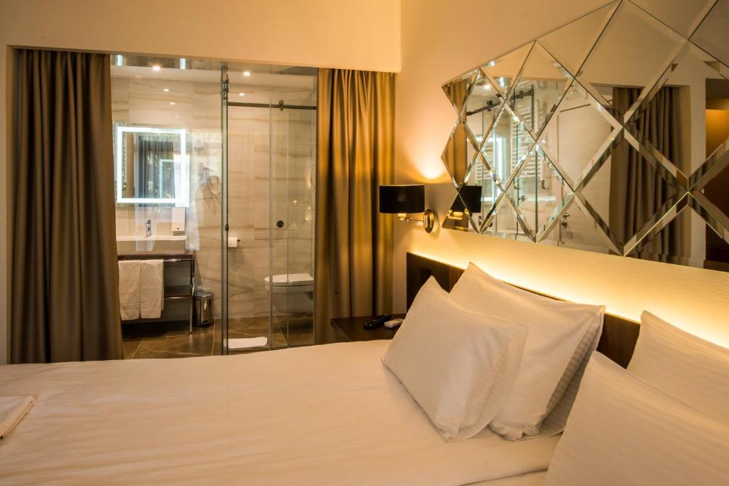 une chambre d'hôtel avec un lit et une douche dans l'établissement Hotel Spa Grad, à Kovin