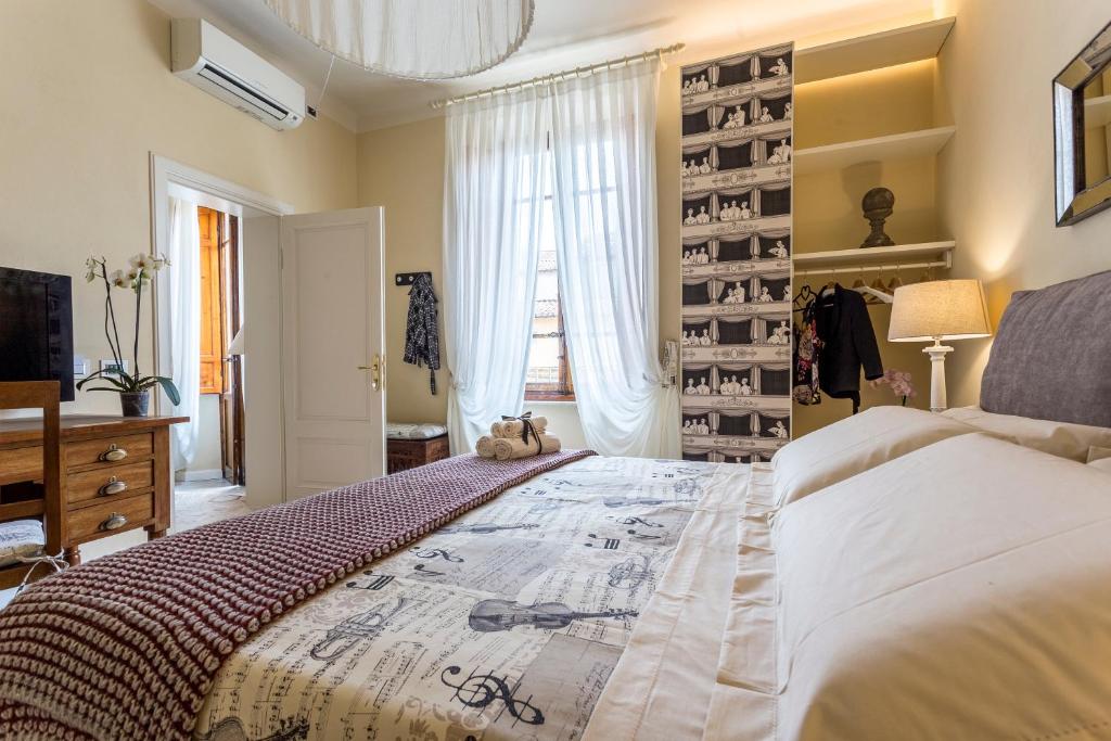 a bedroom with a large bed and a window at Perle d'Ambra in Lucca