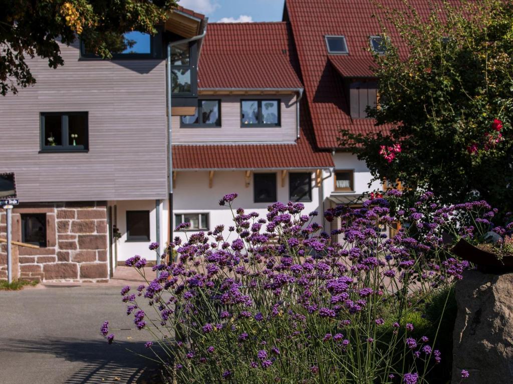 a garden with purple flowers in front of a building at Saunaloft Schwarzwald in Gemeinde Aichhalden