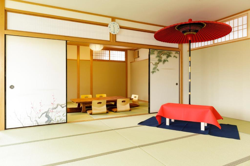um quarto com uma mesa e um guarda-chuva vermelho em 日照庵 Nisshouan em Quioto