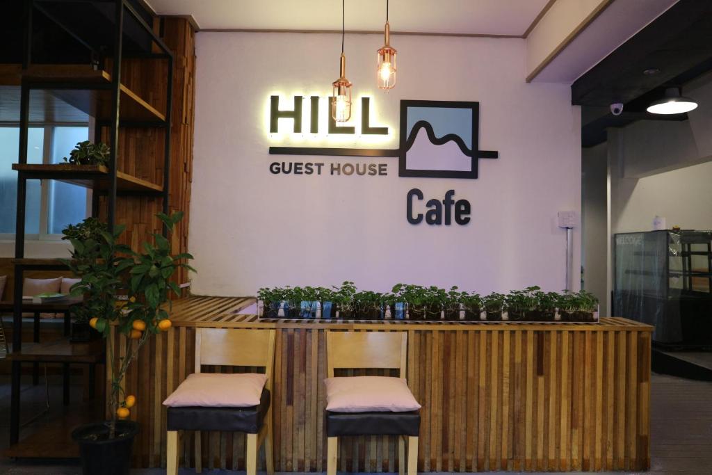 a restaurant with a counter with stools and a guest house cafe at Nampo HILL Guesthouse in Busan