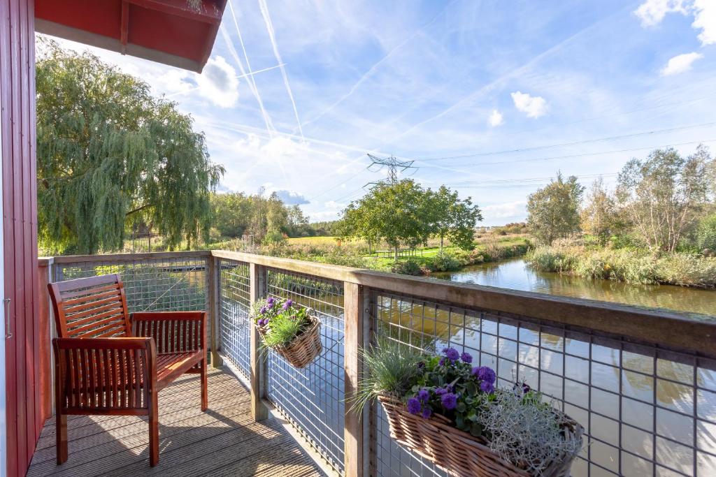 a balcony with a chair and a view of a river at Hajé Restaurant de Aalscholver in Lelystad