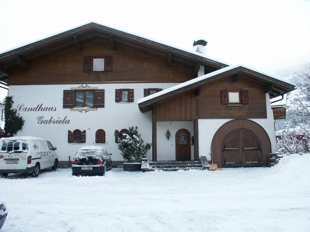 a house with a car parked in the snow at Landhaus Gabriela in Stumm